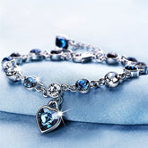 Heart of Ocean Bracelet – silver chain with blue and clear crystals and heart pendant on blue fabric, elegant romance