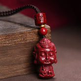 Chinese Zodiac Cinnabar Pendant – Carved red Buddha figure on braided cord against rustic wood, spiritual necklace