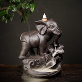 Purple Clay Elephant Backflow Burner – Three-quarter front view with cascading smoke waterfall on dark wood, zen decor