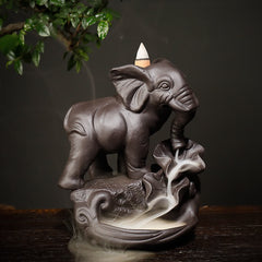 Purple Clay Elephant Backflow Burner – Three-quarter front view with cascading smoke waterfall on dark wood, zen decor