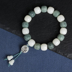 White Bodhi Seed Om Mani Padme Hum Bracelet – Flat lay on slate and linen, carved bodhi seed beads