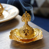 Gold Leaf Coaster Incense Burner with smoke rising from pierced dome, lotus base on wood, alloy incense burner