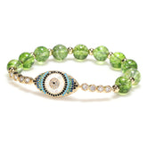 Peridot green crackle bead bracelet with gold evil eye pave crystal charm on white background
