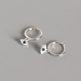 Silver Evil Eye Stud Earrings with Blue Center Stone on Gray Background, Evil Eye Charm