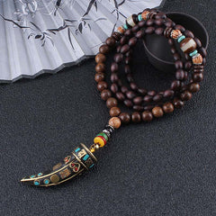 Wenge Wood Horn Pendant Necklace – Full length on dark surface with fan prop, mala necklace