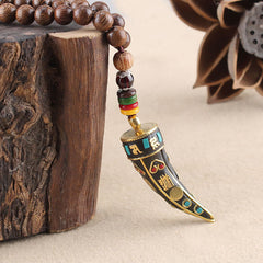 Wenge Wood Horn Pendant Necklace – Macro of carved horn pendant with gold mantra, boho necklace