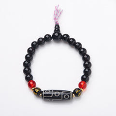 Tibetan Nine-Eye Dzi Bead Black Onyx Bracelet – overhead shot on white, full loop with guru bead & tassel, onyx mala