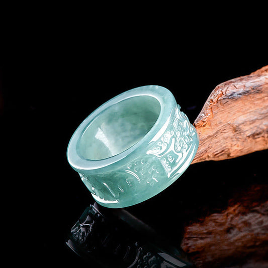 Jade Om Mani Padme Hum Ring – Low-angle on driftwood with reflection, carved jade