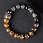 Om Mani Padme Hum Bracelet – Flat lay on dark fabric showing three stone types and carved metal