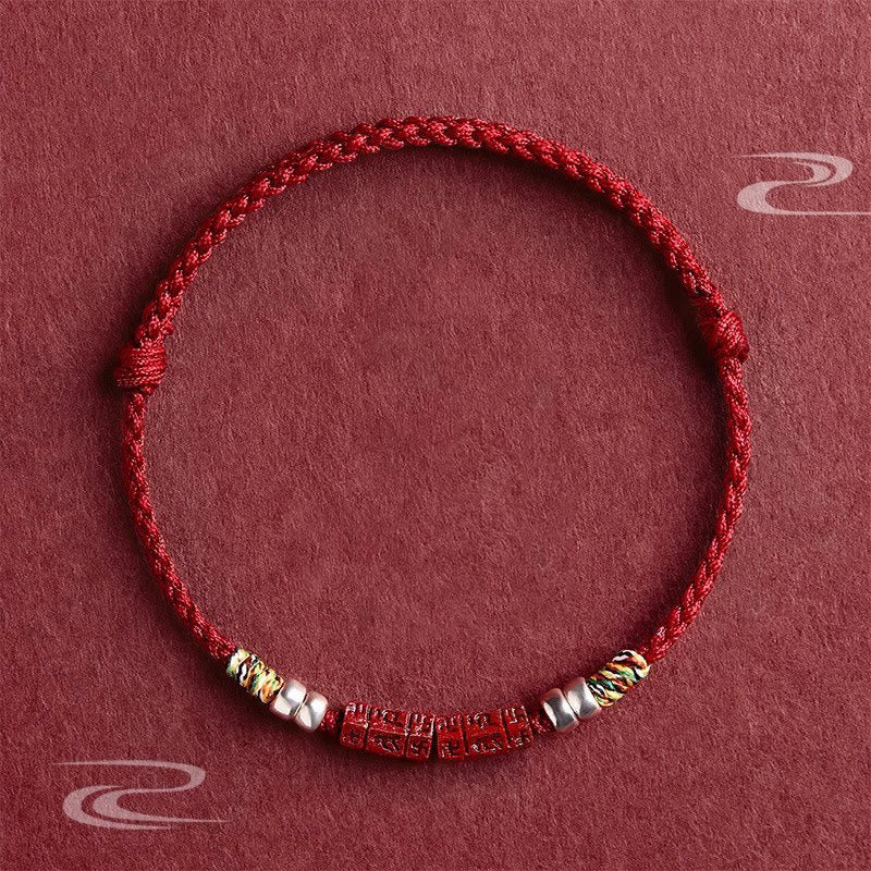 Cinnabar Om Mani Padme Hum Red String Bracelet – flat lay with carved mantra beads and silver accents, blessing protection