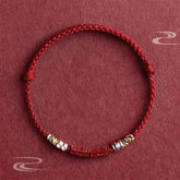 Cinnabar Om Mani Padme Hum Red String Bracelet – flat lay with carved mantra beads and silver accents, blessing protection