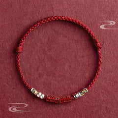 Cinnabar Om Mani Padme Hum Red String Bracelet – flat lay with carved mantra beads and silver accents, blessing protection