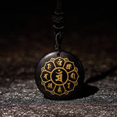 Om Mani Padme Hum Necklace – Black obsidian disc with gold lotus mantra on dark backdrop, obsidian amulet