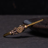 PiXiu Copper Bangle – Antique brass cuff with PiXiu and compass charm on dark plate side view