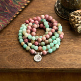 Mala Rhodonite Amazonite Lotus Bracelet - coiled on wood with fabric, mindful serenity