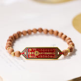 Sandalwood Bead Bagua Yin Yang Bracelet - elevated angle on book pages showing red enamel hexagonal pendant, wooden bead j...