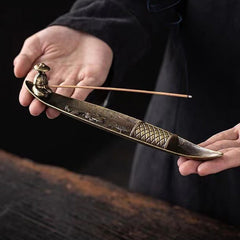 Koi Fish Boat Incense Burner - bronze fishing boat with seated fisherman and burning incense, dark moody