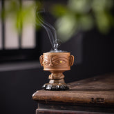 Sanxingdui Ceramic Incense Burner – yellow mask face with phoenix lid emitting smoke by window, zen home decor