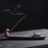 Fisherman Boat Purple Clay Incense Burner – side view with smoke drifting over dark tea tray, serene zen decor