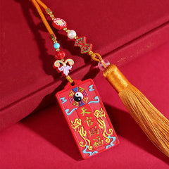 Natural Cinnabar Bagua Yin Yang Fu Hanging - three-quarter view on red fabric showing bagua pendant with beaded tassel, fe...