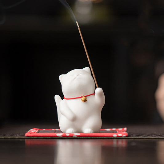 Cat Bell Ceramic Incense Burner – White cat with red bell collar holding lit incense, smoke rising, ceramic incense burner