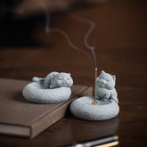 Lazy Cat Sandstone Incense Burner – two cat figurines, sleeping and seated, on dark wood with book, incense burning, zen d...