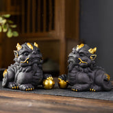 PiXiu Ingot Ball Purple Clay Tea Pet – Pair of black PiXiu with gold accents on wooden tea mat, feng shui wealth decor