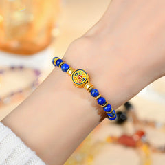 Lapis Lazuli Bracelet – worn on wrist with warm bokeh background showing gold spacers and medallion, balance