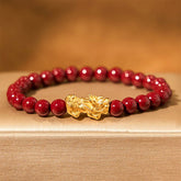 Natural Cinnabar Beads PiXiu Blessing Bracelet – gold PiXiu with glossy red cinnabar beads on beige fabric, protection bracelet