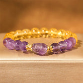 Citrine Amethyst PiXiu Prosperity Bracelet – purple amethyst PiXiu with citrine and amethyst beads on beige fabric, wealth