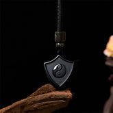 Black Obsidian Shield Pattern Yin Yang Streng - Black obsidian yin-yang shield pendant on driftwood, polished amulet necklace