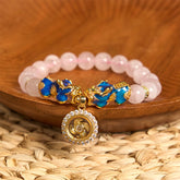 Pink crystal beads with double enamel PiXiu and spinner on wooden bowl