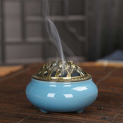 Colorful Ice Crackle Incense Burner – Blue ceramic with brass lid, smoke rising on dark wood, meditation