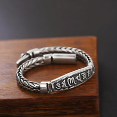 Vajra Om Mani Padme Hum Bracelet – Three-quarter view of braided chain with mantra engraving on wood, peace bracelet