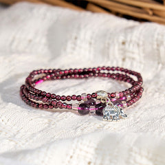 Natural Garnet PiXiu Elephant Abacus Lucky Bag Bracelet – garnet bracelet on white knit fabric with elephant charm, spiritual accessory