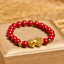 Cinnabar Pixiu Calm Bracelet – front view on gold box, single strand red cinnabar beads with large gold Pixiu charm center, feng shui
