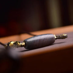 Tibetan Dzi Bead Agate Protection Pendant – side profile macro, cylindrical dzi stone with gold end caps, agate amulet