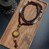 Tibetan Om Mani Padme Hum Necklace – Full mala on wood tray, cloisonné deity pendant, dark fabric backdrop