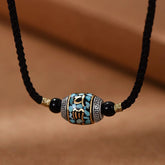 Dzi Bead Om Mani Padme Hum Rotatable Pendant – Frontal view of turquoise inlay barrel bead on black cord, tibetan pendant