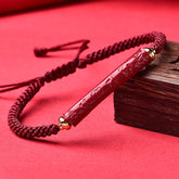 Cinnabar Heart Sutra Blessing Bracelet – carved red bead on burgundy cord with gold caps, cinnabar bracelet
