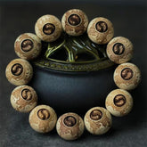 Camphor Wood Yin Yang Ox Engraved Bracelet - carved yin-yang beads on dark display, wood jewelry