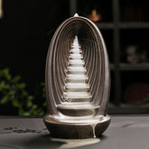 Mountain Water Buddha Hand Incense Burner – Dark ceramic arch with tiered pagoda, white smoke waterfall