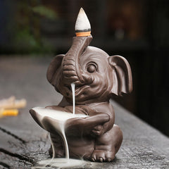 Elephant Backflow Incense Burner - Frontal view with smoke flowing into lotus bowl, purple clay censer