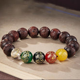 Five Directions Wealth Bracelet - Carved sandalwood beads with five-element gemstone accents on parchment, spiritual jewelry