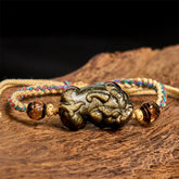 Gold Sheen Obsidian PiXiu bracelet – rope bracelet on wooden surface front view, protection good luck