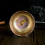 Jianzhan Koi Fish Lotus Teacup – golden-bronze iridescent glaze, gold koi and lotus interior, dark wood, angled top view