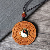 Jujube Wood Yin Yang Bagua Necklace – Carved bagua trigram pendant with yin-yang center on gray fabric, wooden amulet jewelry