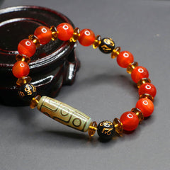 Red Agate Nine-Eye Dzi Bead Bracelet – directional lighting on eye-pattern beads and gold-inscribed mantra beads, wood stand