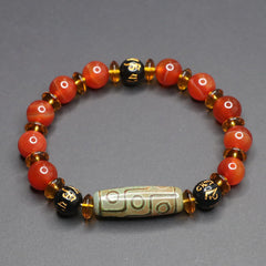 Red Agate Nine-Eye Dzi Bead Bracelet – top-down view on gray, warm carnelian beads with cylindrical dzi focal bead