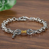 Copper Vajra Om Mani Padme Hum Bracelet – silver vajra centerpiece with gold accent on wooden surface, spiritual jewelry